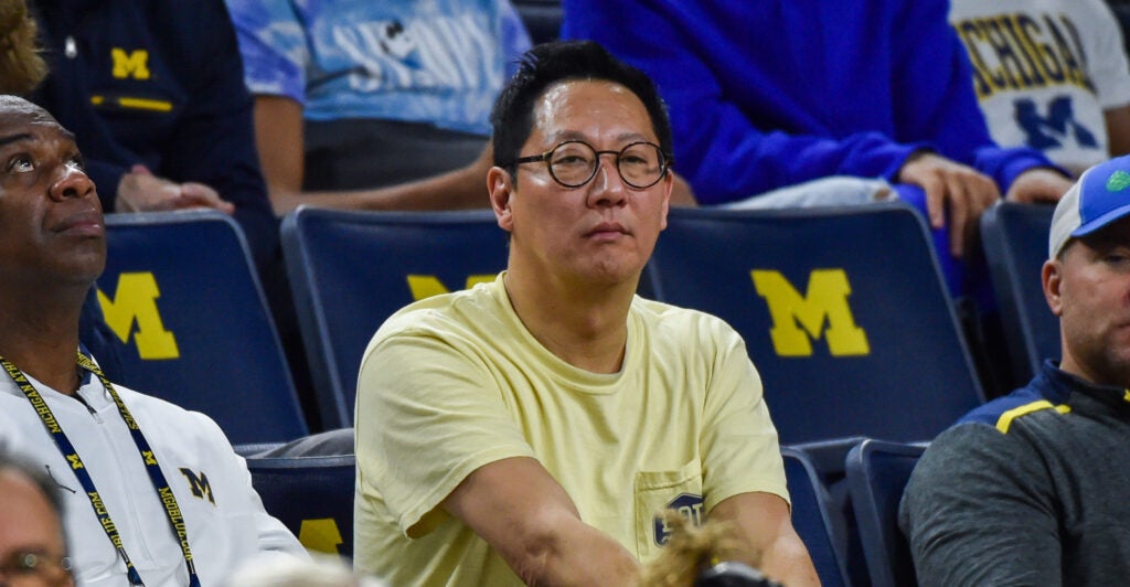 Santa Ono, the president of the University of Michigan, in a yellow T-shirt at a college basketball game