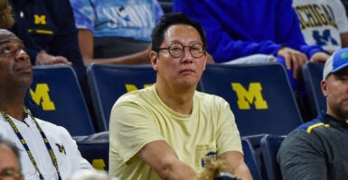 Santa Ono, the president of the University of Michigan, in a yellow T-shirt at a college basketball game