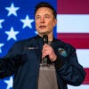 Elon Musk speaks at an event in Lancaster, Penn., with a U.S. flag as a backdrop.