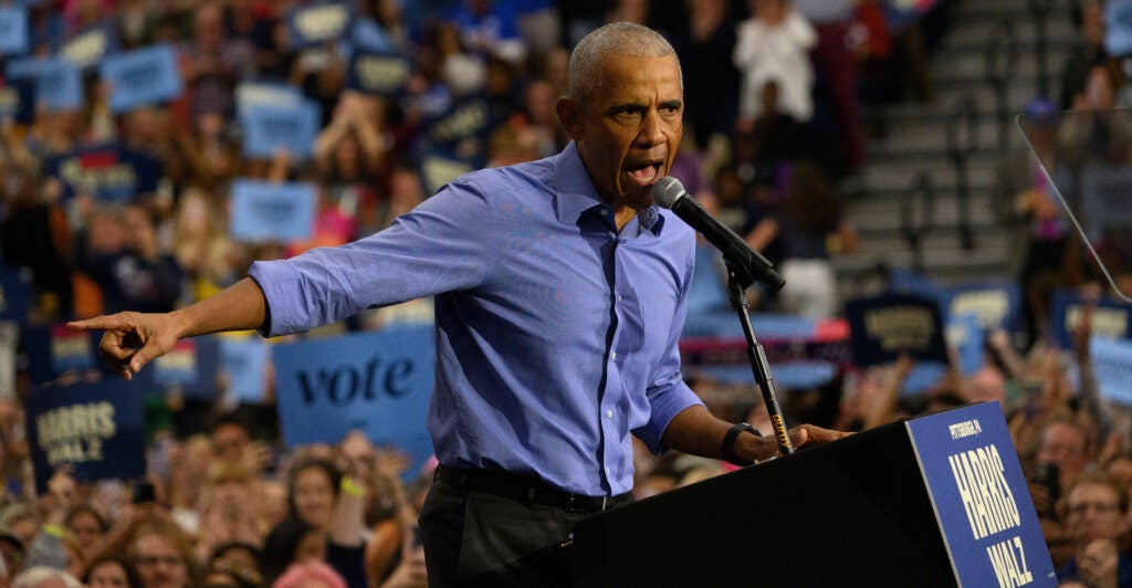 Former President Barack Obama, in a blue shirt but no jacket or tie, addresses a campaign rally for Vice President Kamala Harris on Oct. 10 in Pittsburgh.