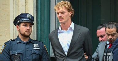 Daniel Penny is being escorted in handcuffs by the New York Police Department