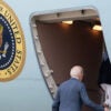 President Joe Biden, seen from behind, boards Air Force One.