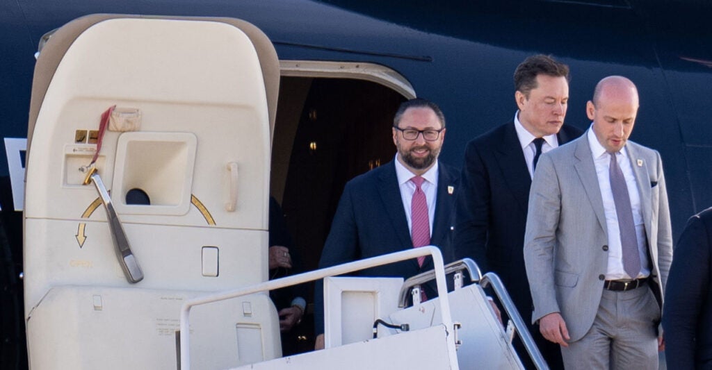 From left, Jason Miller, Elon Musk, and Stephen Miller disembark with President-elect Donald Trump at Joint Base Andrews, Maryland. Musk and Stephen Miller could clash over the incoming administration's legal-immigration policies.