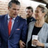 Pete Hegseth, in a blue suit and red tie, walks arm in arm with wife Jennifer Rauchet after visiting Sen. Tom Cotton on Thursday on Capitol Hill.