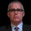 Andrew McCabe in a suit stares ahead