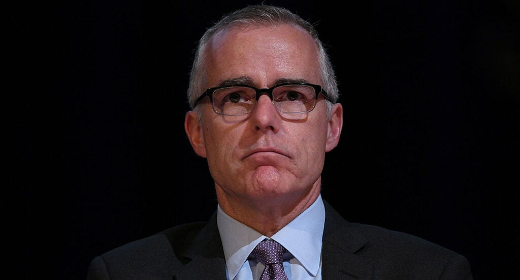 Andrew McCabe in a suit stares ahead