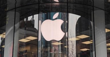 The Apple logo appears on a glass window of a building in China in 2024.