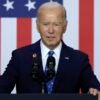 President Joe Biden stands at a podium with an American flag behind him.