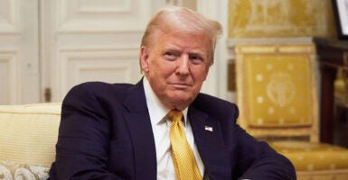 Donald Trump in a black suit with a gold tie, rather than his usual red tie