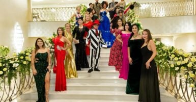 Fashion designer Andre Soriano, in a black-and-white-striped outfit and a bevy of models in his first ladies dresses collection on a stairwell