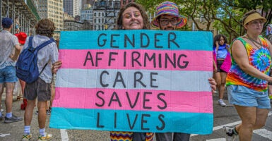 An activist holds a sign reading, 