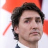 Close-up of Canadian Prime Minister Justin Trudeau with the Canadian flag in the background.