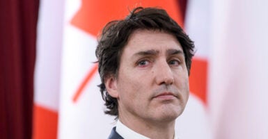 Close-up of Canadian Prime Minister Justin Trudeau with the Canadian flag in the background.