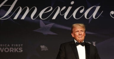 Donald Trump stands on a stage in a tuxedo.