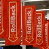 Multiple red "Rollback" banners with white lettering hang in a Walmart Supercenter.