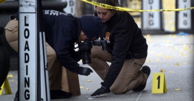 Two police officers work at a crime scene.