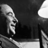 a black-and-white profile picture of C.S. Lewis smiling and near a lamp