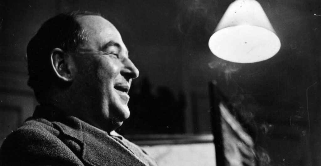 a black-and-white profile picture of C.S. Lewis smiling and near a lamp