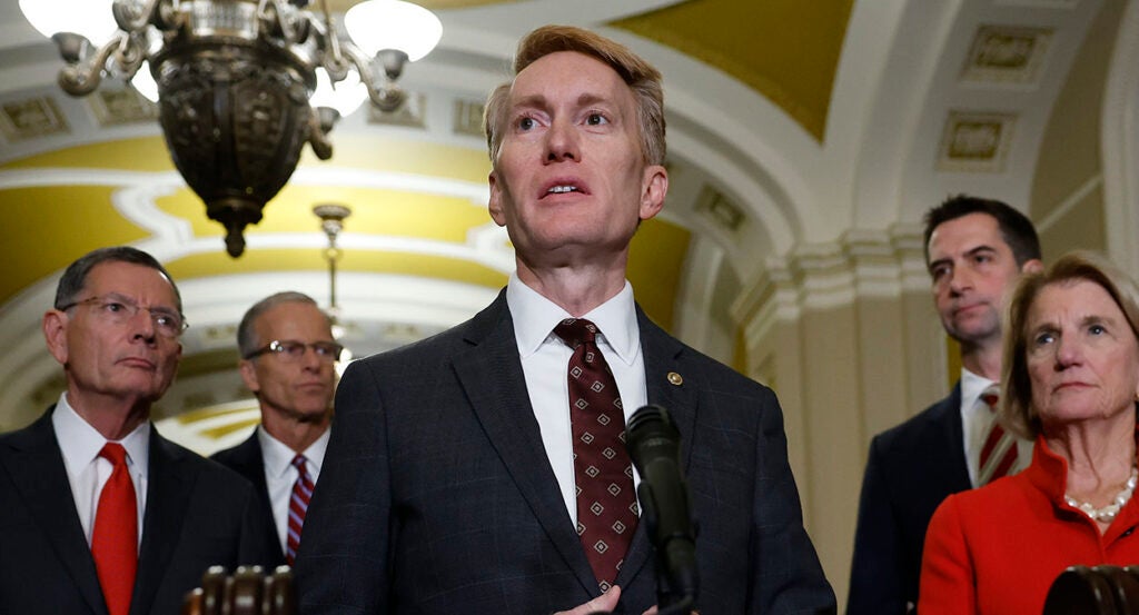 James Lankford in a suit speaks in front of a microphone