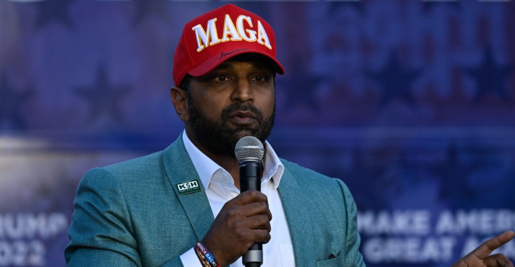 Kash Patel wearing a red MAGA (Make America Great Again) baseball cap