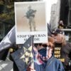 A woman holds up a sign at a rally that says, "Stop Veteran Suicide."