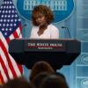 White House press secretary Karine Jean-Pierre speaks during a news conference, standing next to an American flag.