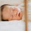 A baby sleeps soundly in a crib