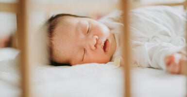 A baby sleeps soundly in a crib