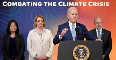 President Joe Biden, joined by (l-r) acting Labor Secretary Julie Su, FEMA Administrator Deanne Criswell, and National Oceanic and Atmospheric Administration Administrator Dr. Rick Spinrad, speaks during a briefing on climate change with a sign in the background that says, "Combating the Climate Crisis."