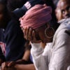 A woman holds her head in defeat at a Kamala Harris rally.