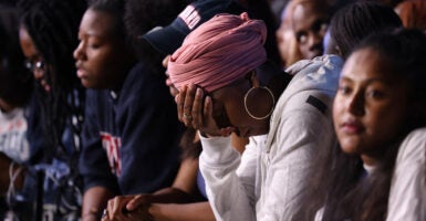 A woman holds her head in defeat at a Kamala Harris rally.