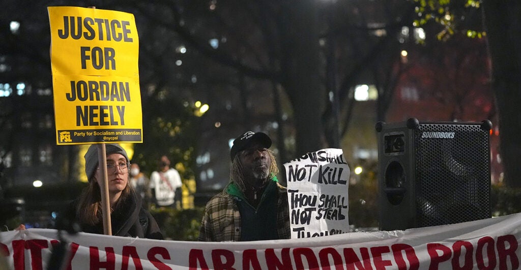 Activist groups protest the death of Jordan Neely in New York City, one holding a large, yellow sign that reads, "Justice for Jordan Neely."