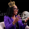 Supreme Court Justice Ketanji Brown Jackson wears a purple blazer and smiles with her hands up. She is superimposed wearing a crown and holding a skull.