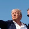 Donald Trump, in a suit, pumps his fist in the air as blood drips down his face after the assassination attempt in Butler, PA.