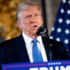 Trump, in a navy suit and a bright blue tie, stands behind a podium and speaks at a news conference at his Mar-a-Lago.