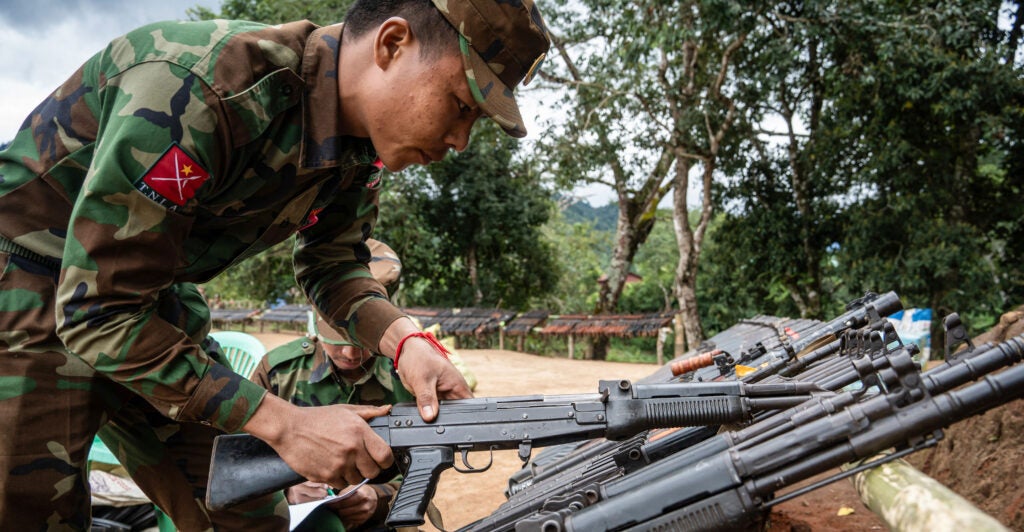 A member of the Ta'ang National Liberation Army in Burma grabs a rifle.