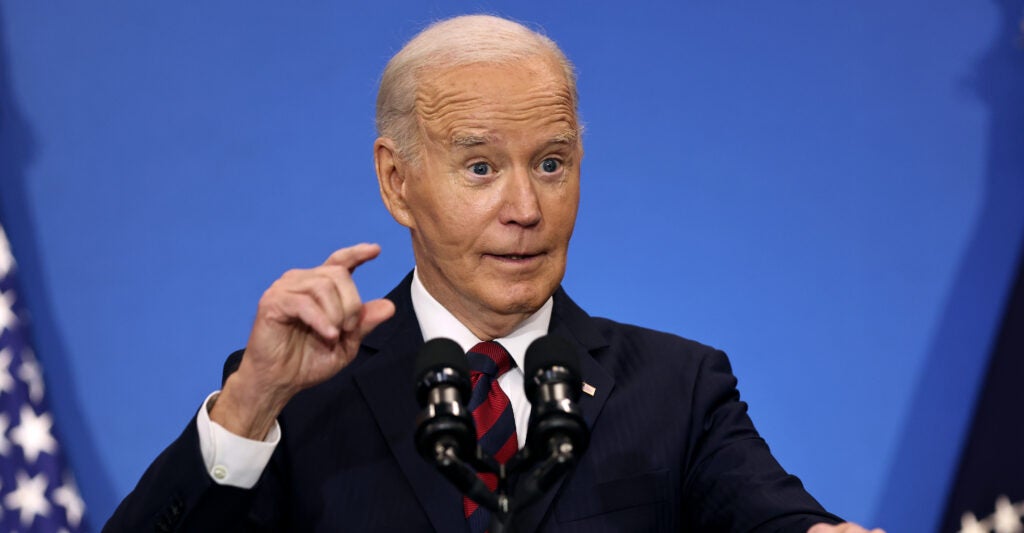 Joe Biden gestures in a suit