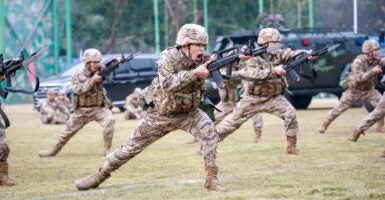 China's Armed Police officers hold rifles while yelling in a training exercise.