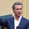 Gavin Newsom in a blue suit points