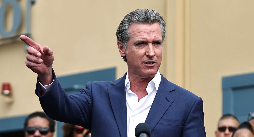 Gavin Newsom in a blue suit points