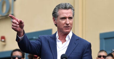 Gavin Newsom in a blue suit points