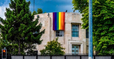 A Pride flag hangs off of a building.