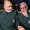 Head of Iranian revolutionary guard corps Hossein Salami and head of the Iranian Quds forces Ismael Ghaani sit next to each other at an event.