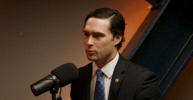 Rep. Brandon Gill in a dark suit sitting next to a microphone