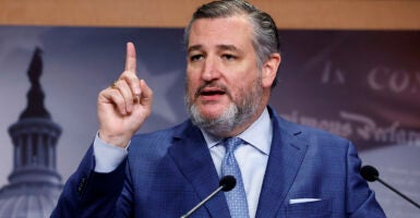 Sen. Ted Cruz raises his finger in a blue suit