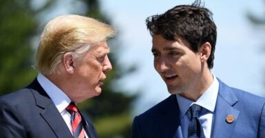 U.S. President Donald Trump stands next to Canada's Prime Minister Justin Trudeau during a conversation.