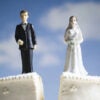 Wedding cake with bride and groom toppers splits down the middle