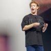 Facebook founder Mark Zuckerberg stands on a stage and talks to someone in the audience.