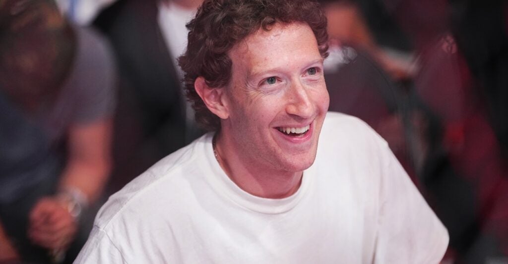 Facebook founder Mark Zuckerberg laughs while wearing a T-shirt.