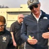 Mayor Karen Bass chats with Gov. Gavin Newsom, who is in a blue jacket and baseball cap, while surveying damage during the Palisades Fire